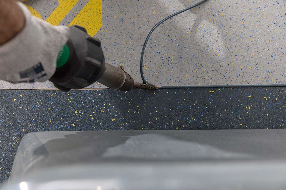 A floor layer welding in an Altro pre-cut logo