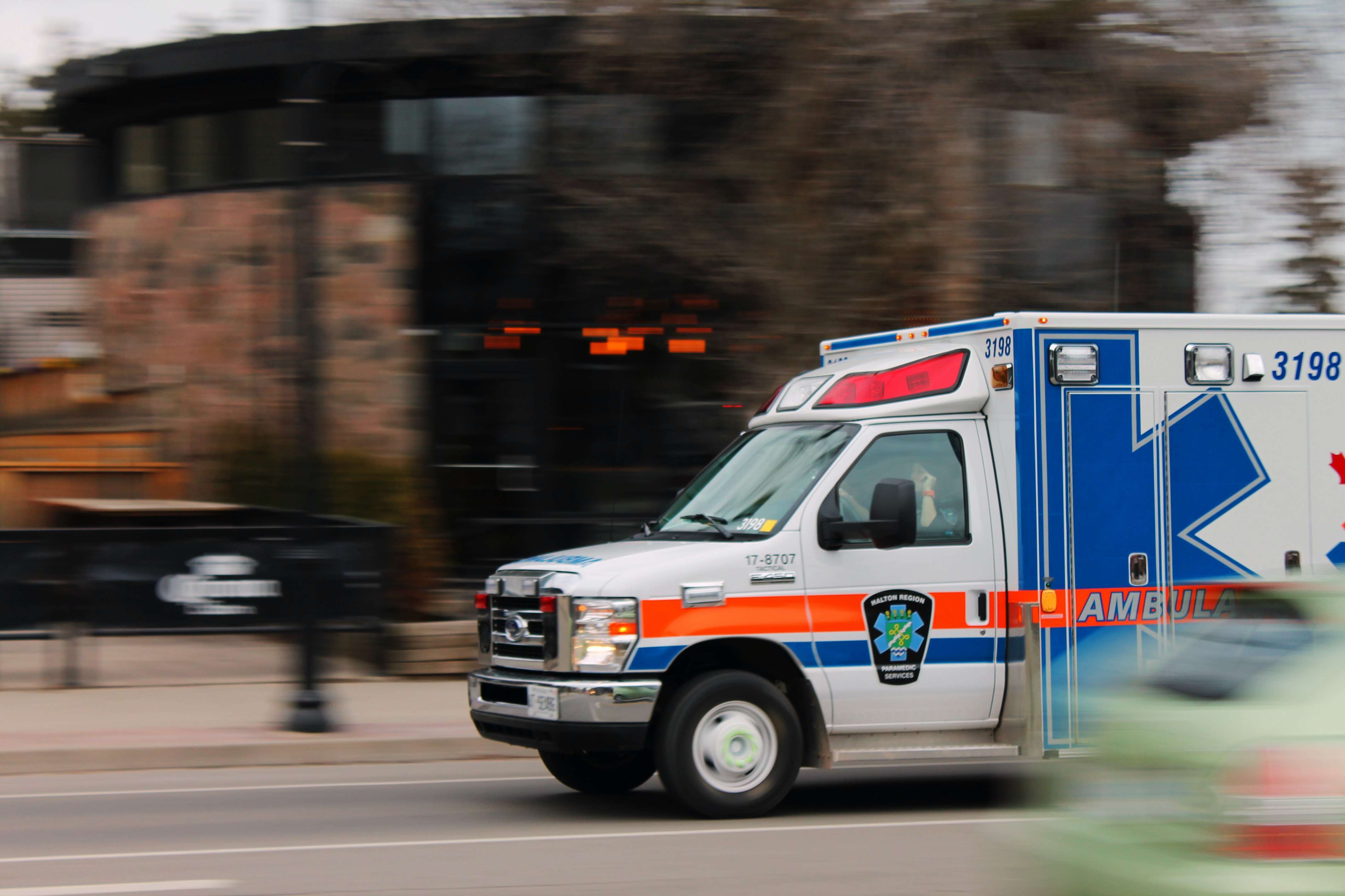 A British ambulance travelling over Westminster Bridge with Big Ben in the background.