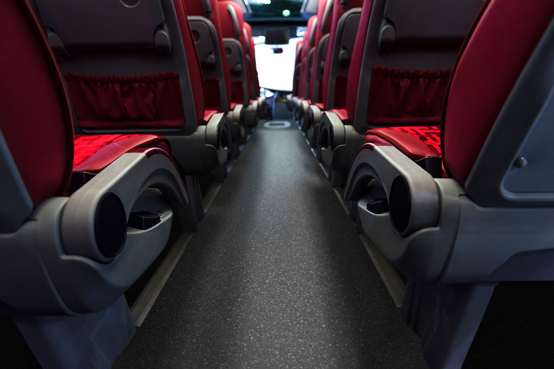 A low-angled shot showing the middle aisle of a coach, toward the front, with Altro Transflor Artis in Onyx installed.
